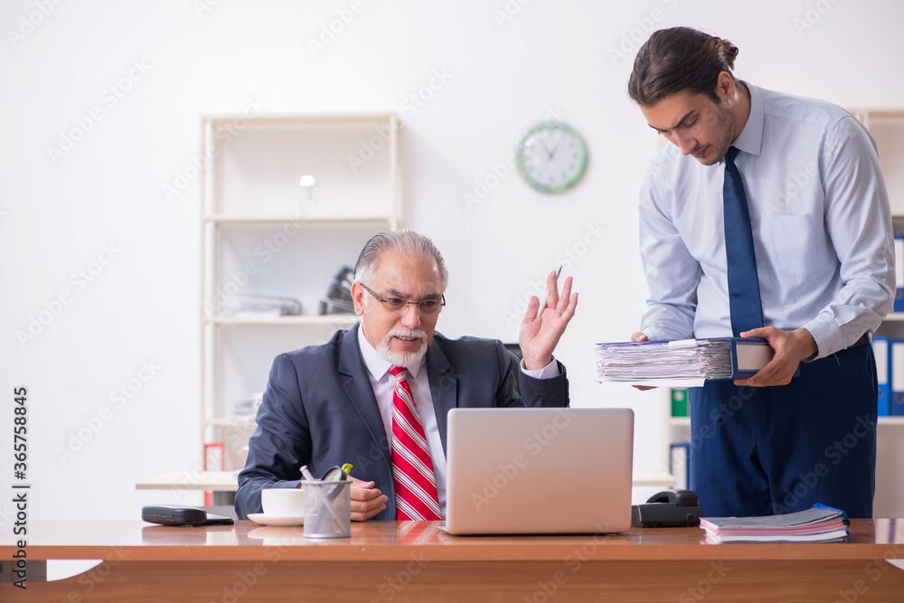 Old boss and young male employee in the office Old boss and young male employee in the office