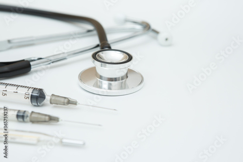 Selective focus of stethoscope , Syringes and thermometer on a white background and copy space