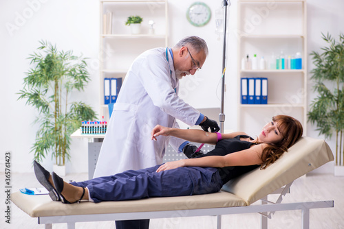 Young woman visiting old male doctor