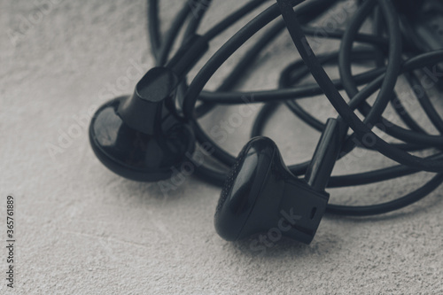 Close-Up Of Tangled Earphones On CConcrete Background photo