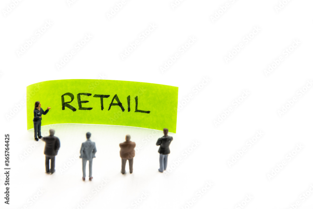 Meeting with miniature figurines posed as business people standing around post-it note with Retail handwritten message in background, minimalist abstract concept with focus on text Meeting with miniature figurines posed as business people standing around post-it note with Retail handwritten message in background, minimalist abstract concept with focus on text
