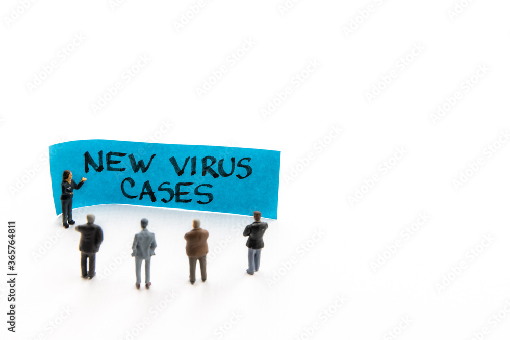 Meeting with miniature figurines posed as business people standing around post-it note with New Virus Cases handwritten message in background, minimalist abstract concept with focus on text Meeting with miniature figurines posed as business people standing around post-it note with New Virus Cases handwritten message in background, minimalist abstract concept with focus on text