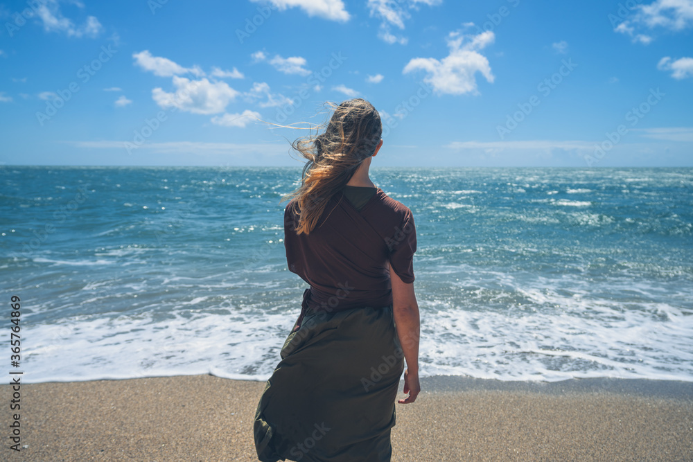 Young woman walking on the beach in summer Young woman walking on the beach in summer