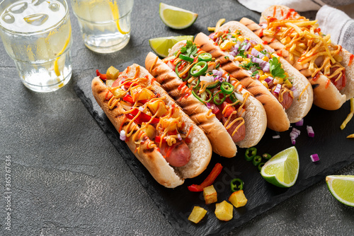 Hot dogs fully loaded with assorted toppings.