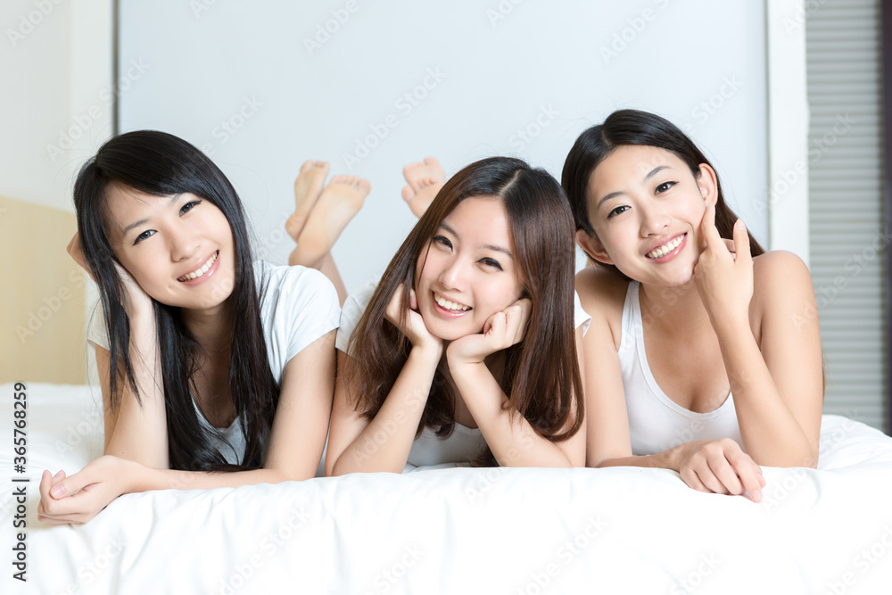 Pretty young girls smiling together in bedroom Pretty young girls smiling together in bedroom