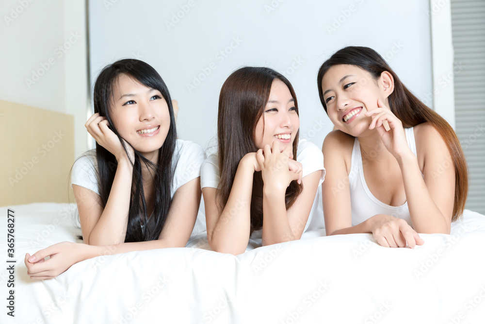 Pretty young girls smiling together in bedroom Pretty young girls smiling together in bedroom