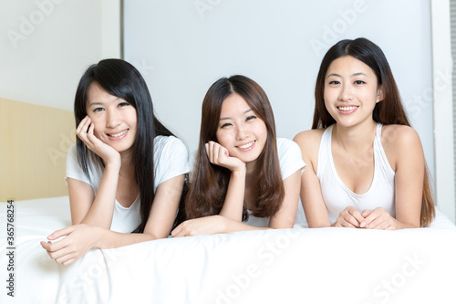 Pretty young girls smiling together in bedroom