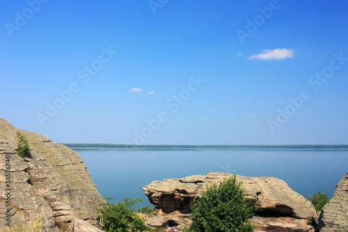 Stone granite rocks on the shore of a blue lake © kos1976