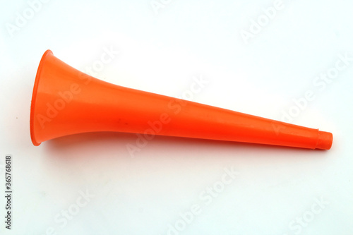 a orange color plastic vuvuzela horn isolated on white background
