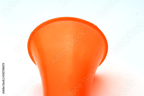 a orange color plastic vuvuzela horn isolated on white background