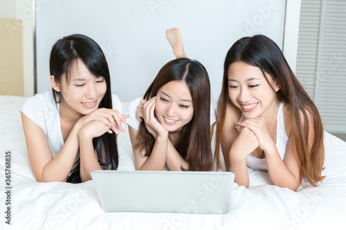 Pretty young girls using laptop in bedroom