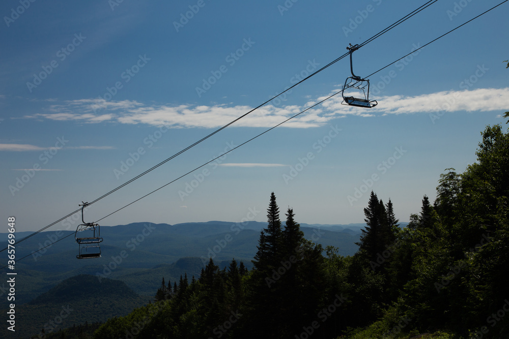 Ski lift strolling across blue sky