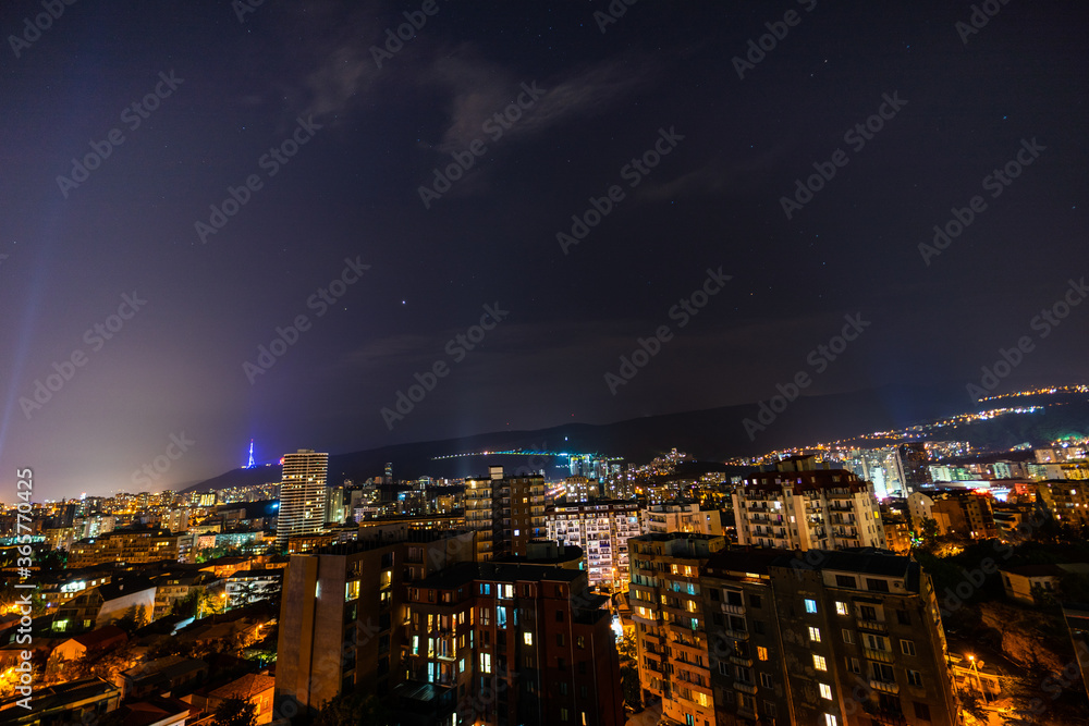 Obraz premium Night sky with stars over Tbilisi's downtown