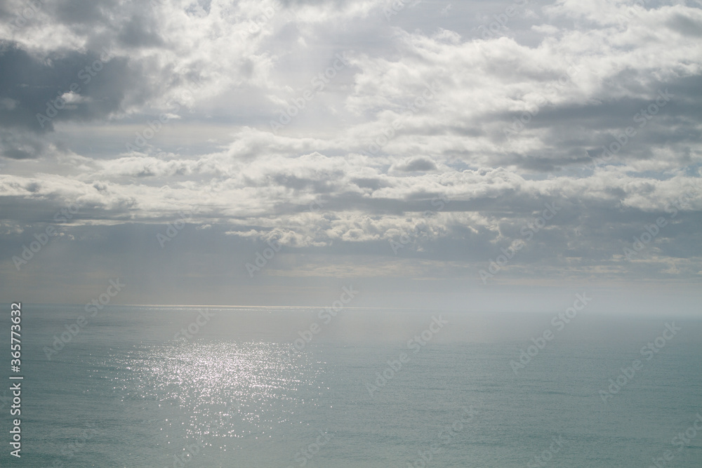 The Seascape in the Mediterranean sea: silver calm sea and sky with clouds and fog.