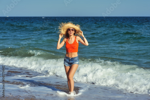 Beautiful young woman on vacation by the sea . Girl in shorts and blouse on the background of the sea
