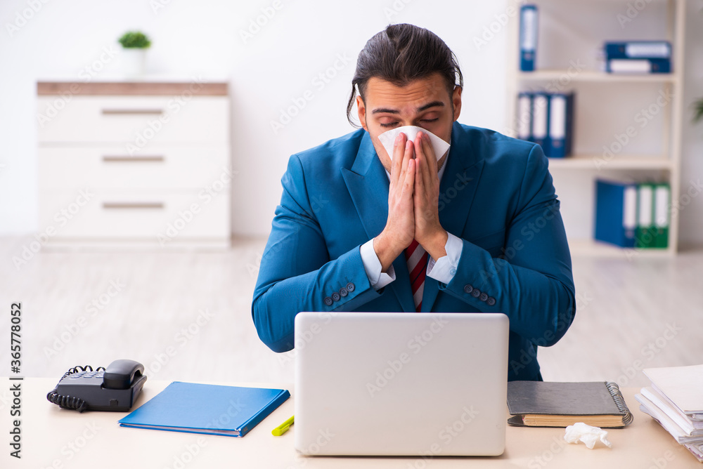 Sick male employee suffering at workplace from coronavirus Sick male employee suffering at workplace from coronavirus