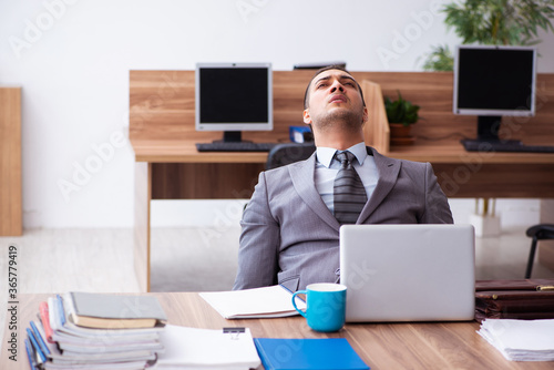 Young male employee unhappy with excessive work