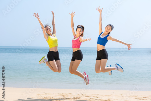 Pretty young girls jumping together at seaside