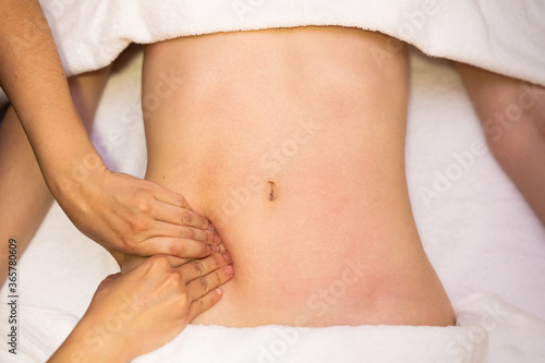Woman receiving a belly massage in a physiotherapy center. © javiindy