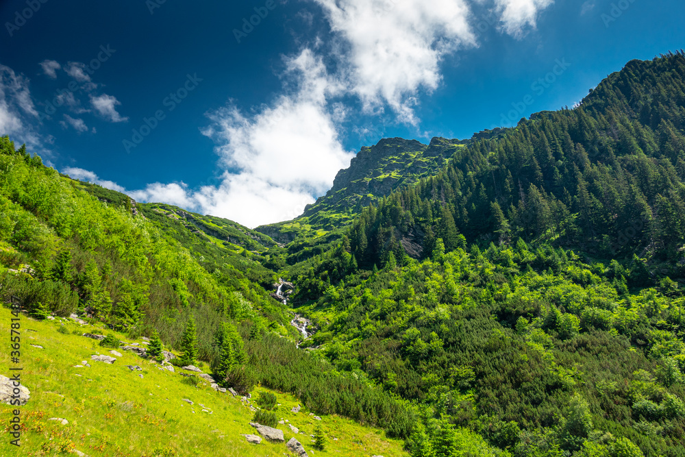 Obraz premium Amazing river waterfall in the heart of the mountains during a sunny day - Romania Fagaras Mountains