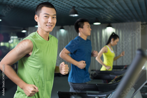 Young people running on treadmill in the gym