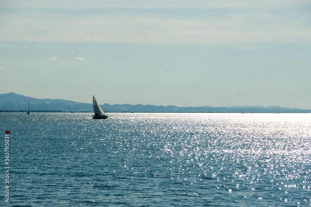 Naklejka premium Spiegelungen auf dem Bodensee mit Segelboot