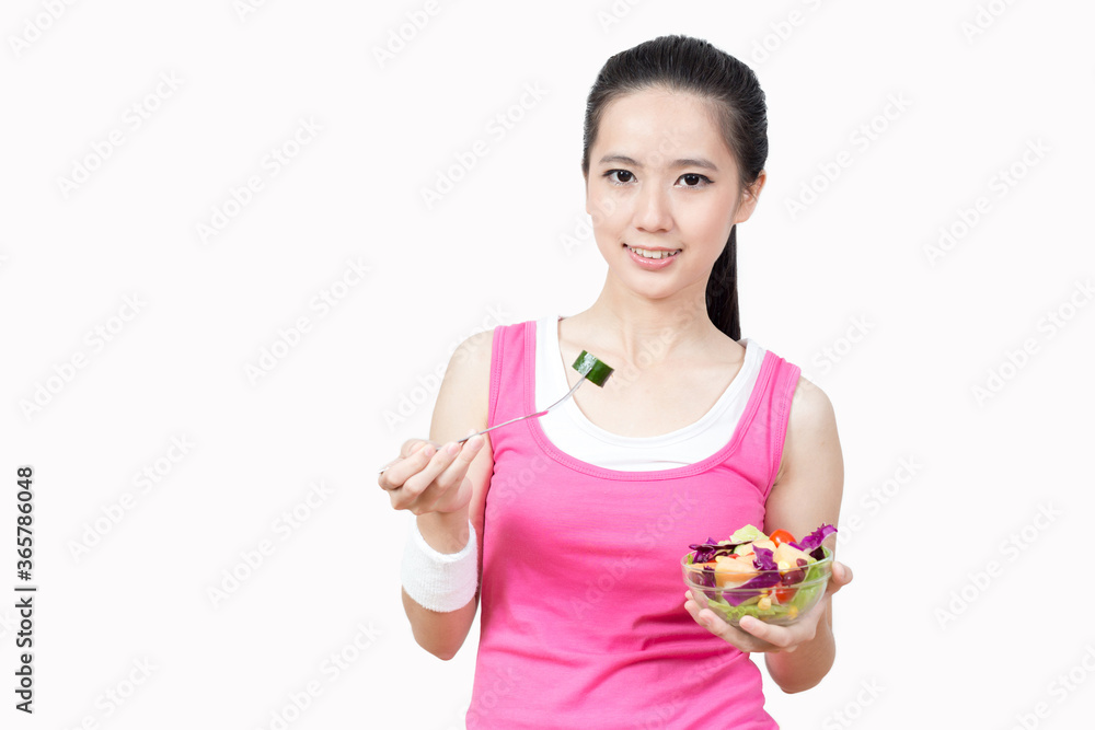 Young Asian woman eating salad after exercise in the gym Young Asian woman eating salad after exercise in the gym