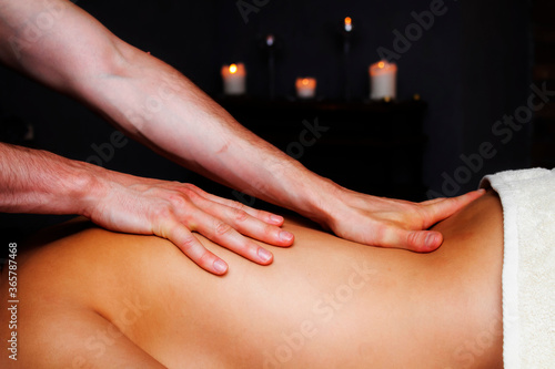 Relaxing oil massage. Masseur's hands. Women's back.