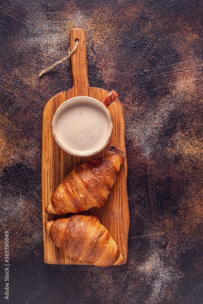 Coffee and croissant on stone background.