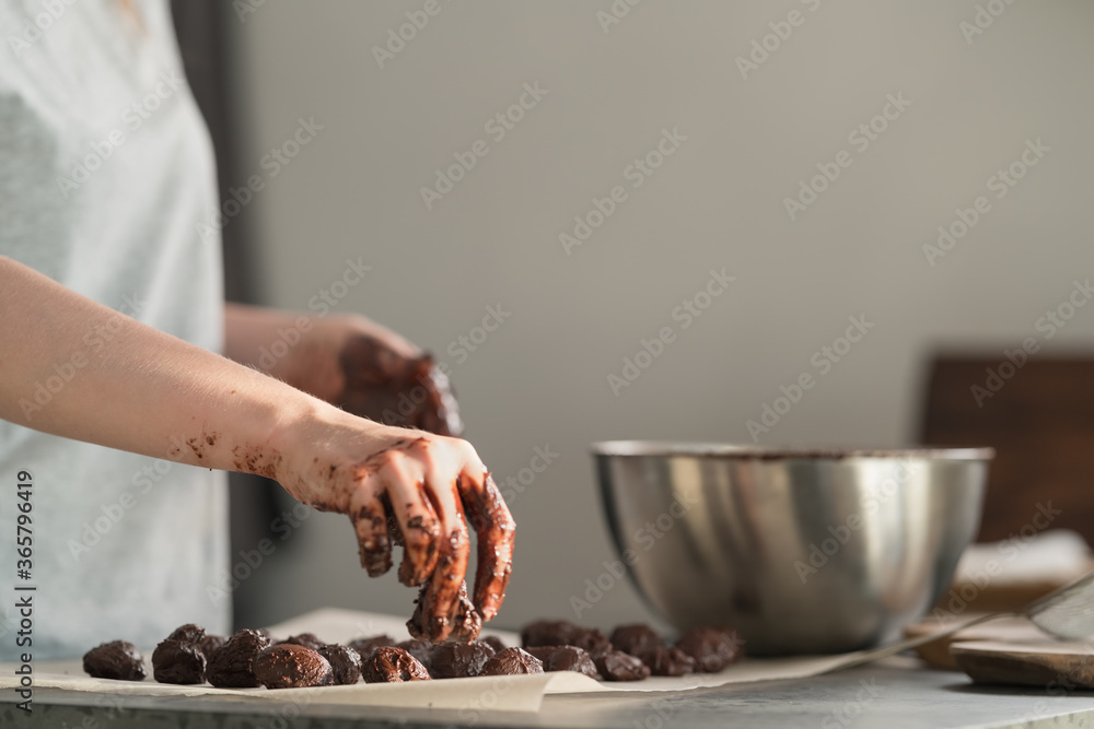 young woman making truffles candy on kitchen