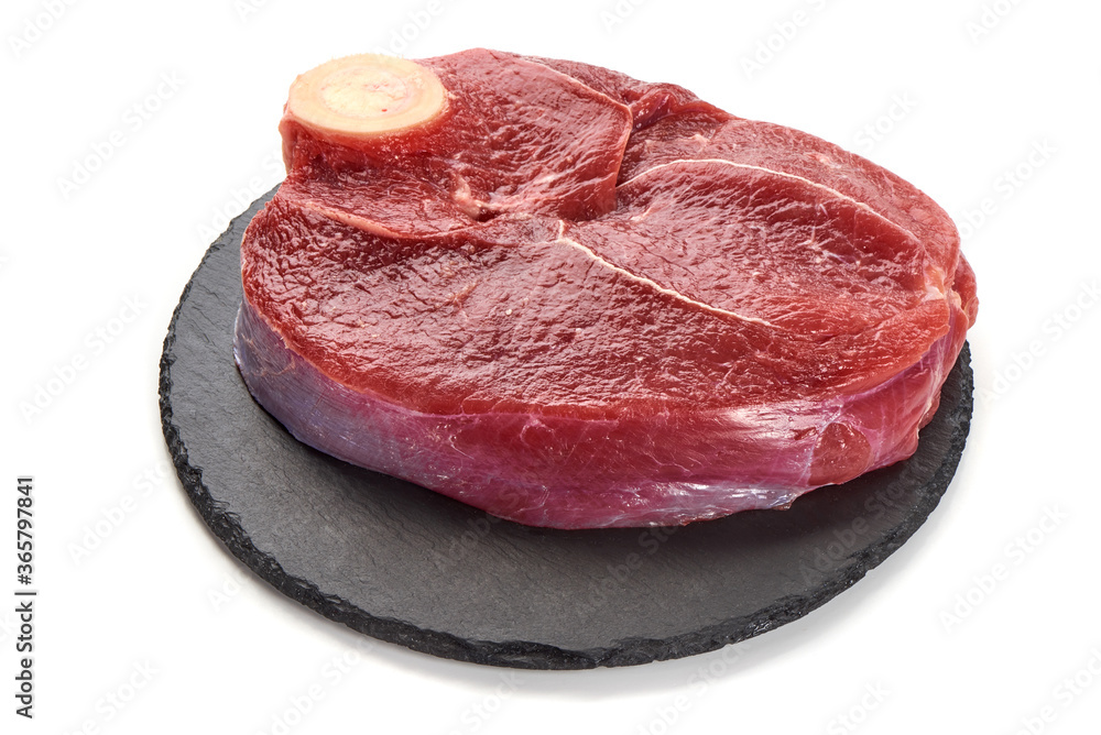 Fresh raw beef meat with bone for steak on stone plate, isolated on white background Fresh raw beef meat with bone for steak on stone plate, isolated on white background