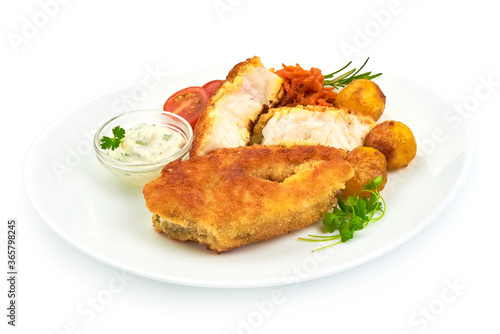Crispy breaded fish fillet with herbs, sauce and tomatoes, isolated on a white background. Close-up