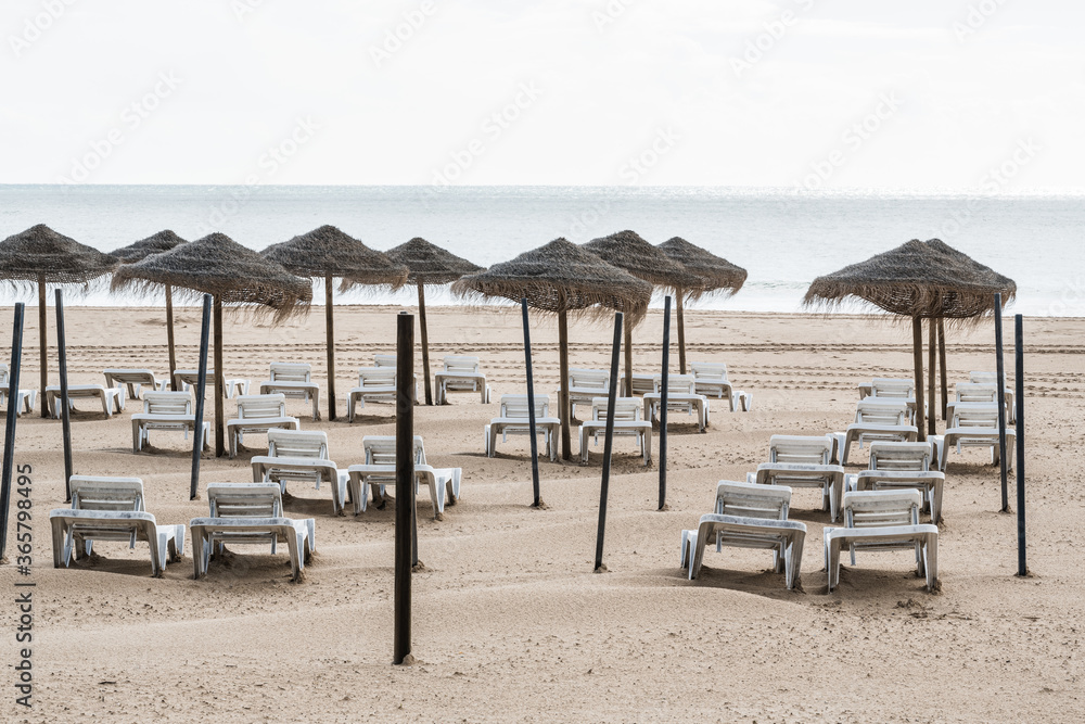 Fototapeta premium Empty deck chairs at beach on quarantine times