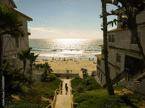 The look of the pacific ocean between the two apartments in la jolla beach in San Diego. People are surfing and swimming in the sea on a sunny day.