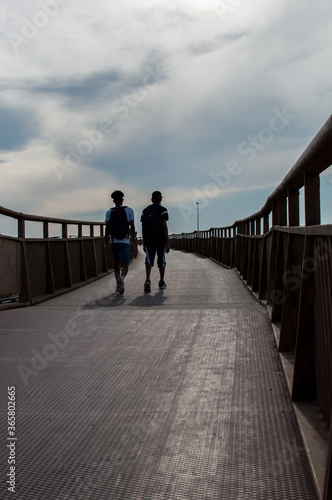 silhouette of a couple crossing a bridge
