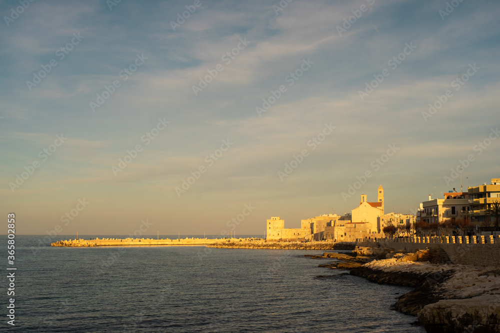 Tourist port of Giovinazzo with defensive walls in the early sunset. Captured taken in the gold hour. Giovinazzo, Metropolitan City of Bari/Apulia (Puglia)/Italy.