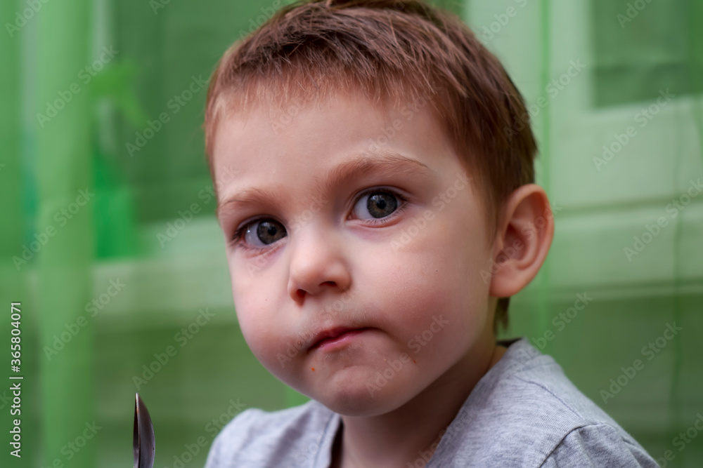 Portrait of a two year old beautiful child. Child eating chocolate cake with a teaspoon Portrait of a two year old beautiful child. Child eating chocolate cake with a teaspoon