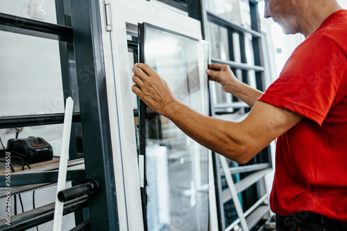 Фотография Manual worker assembling PVC doors and windows