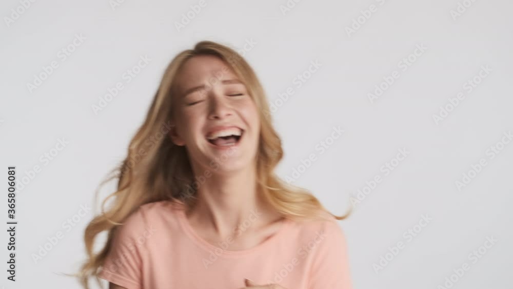 Pretty cheerful blond girl showing no gesture and happily laughing on camera over gray background Pretty cheerful blond girl showing no gesture and happily laughing on camera over gray background