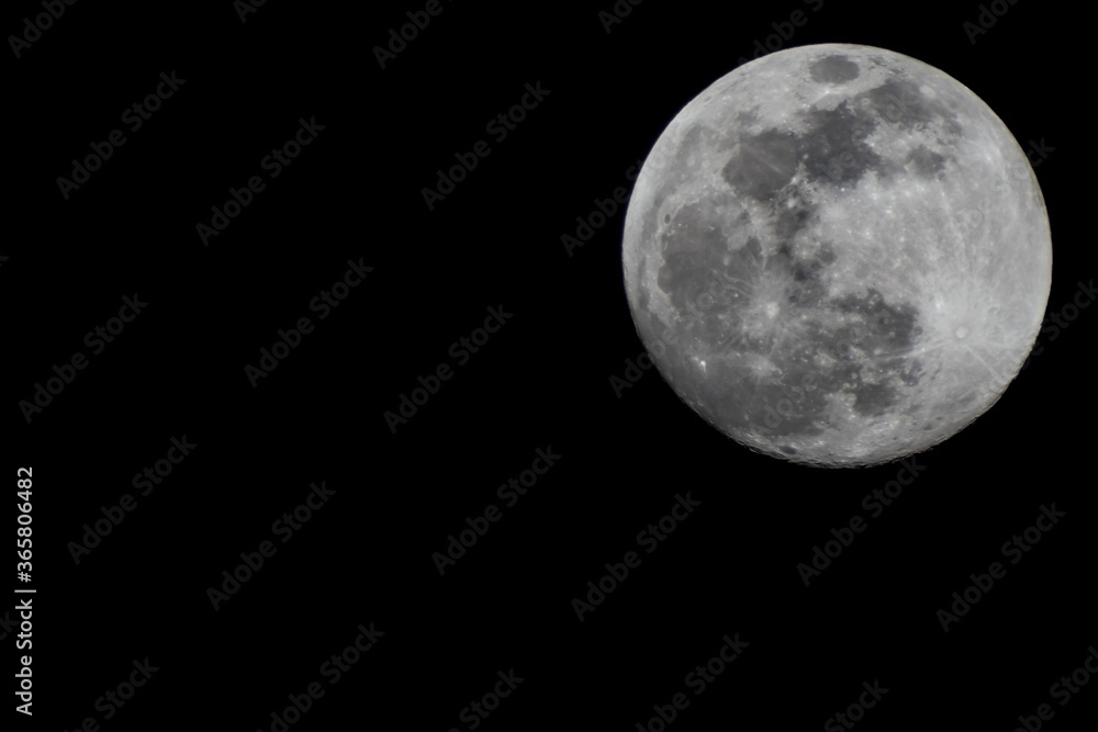 Large full moon, 100% Illumination of lunar disk, seen from Eastern Europe, North hemispere, 700 mm focal lenght. Copy space for text right on black background. Astronomy, astrology, science. Large full moon, 100% Illumination of lunar disk, seen from Eastern Europe, North hemispere, 700 mm focal lenght. Copy space for text right on black background. Astronomy, astrology, science.