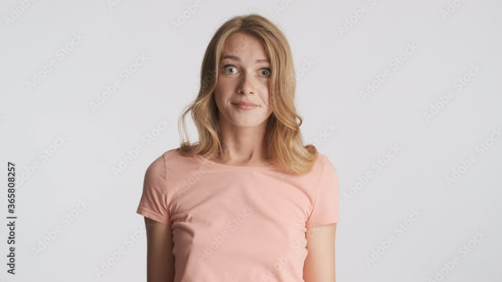 Amazed blond girl throwing up hands thoughtfully looking in camera isolated. I don't know expression Amazed blond girl throwing up hands thoughtfully looking in camera isolated. I don't know expression