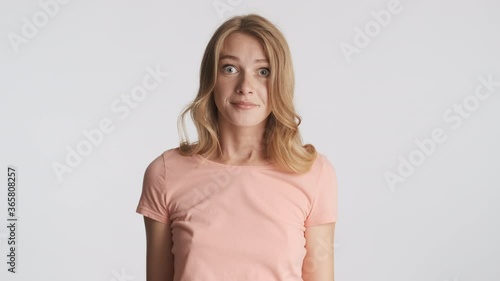 Amazed blond girl throwing up hands thoughtfully looking in camera isolated. I don't know expression