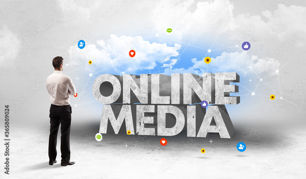 Young businessman standing in front of ONLINE MEDIA inscription, social media concept Young businessman standing in front of ONLINE MEDIA inscription, social media concept
