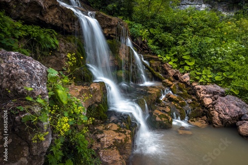 Picturesque waterfall Cascaded surrounded with high grass and trees. Lagi Naki plateau in the Caucasus mountains  Russia.