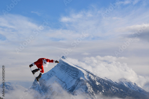 Santa on snowboard flying over a mountain 