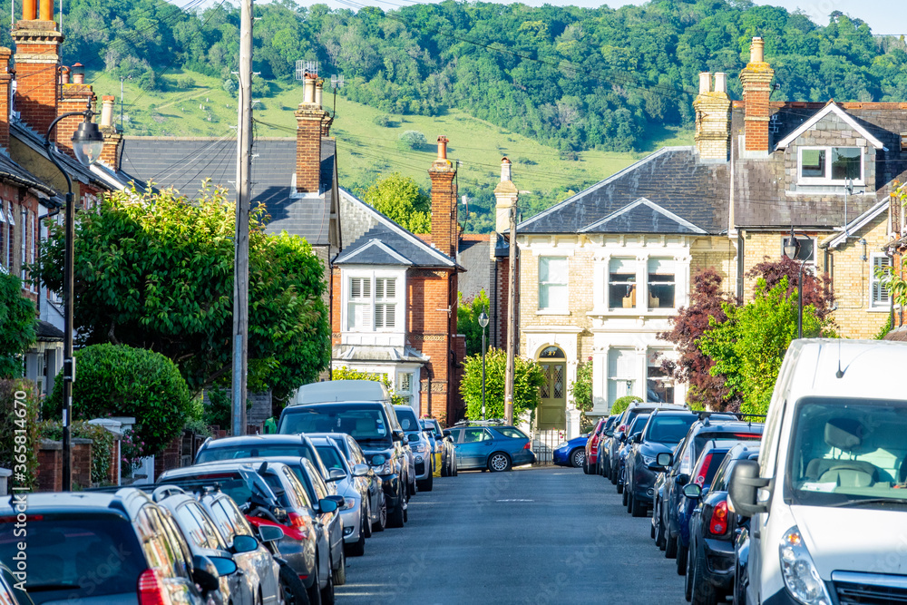 A street of  large residential houses with parked cars in Surrey, south east England 