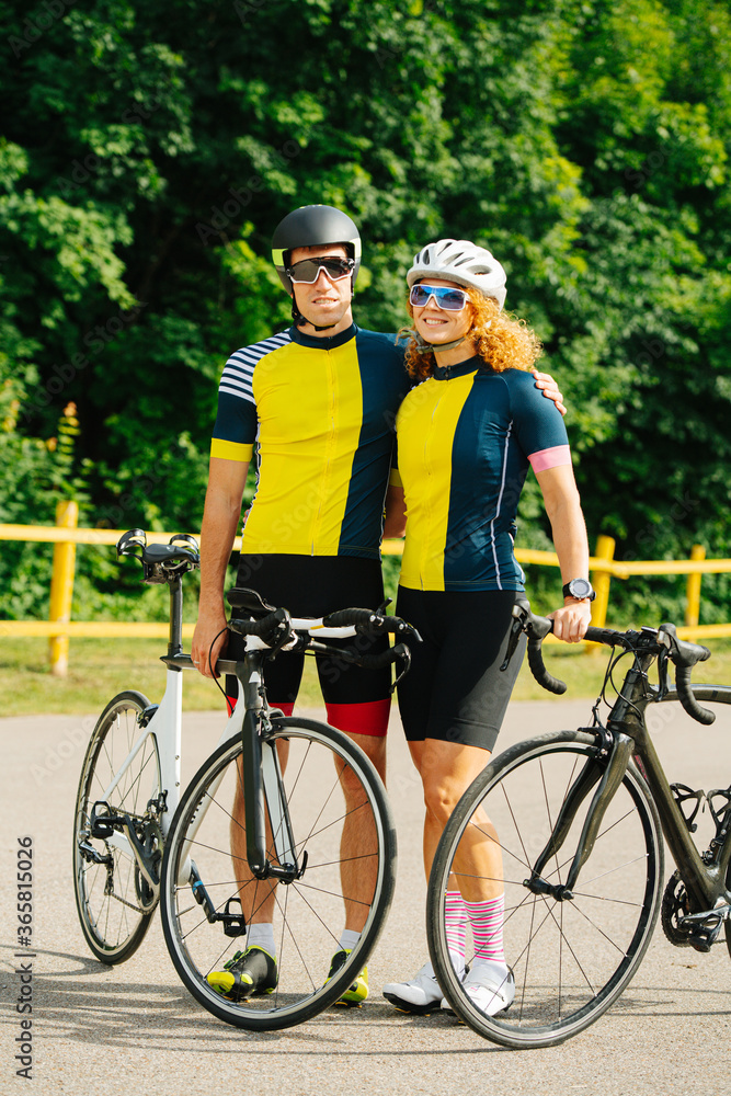 Cute cyclist couple posing with their bikes, wearing same colors