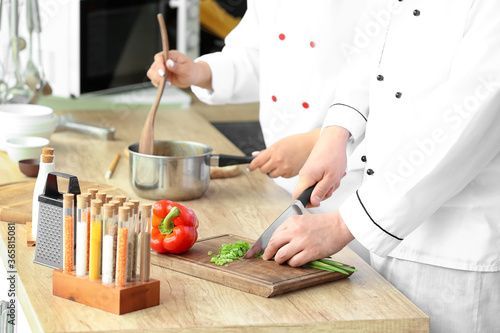 Two chefs preparing food in...