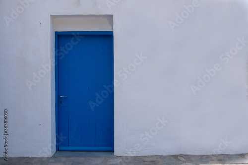 Blue color door on a white wall, greek island architecture, copy space © Rawf8