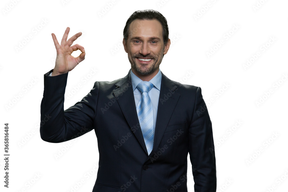 Smiling formal-dressed manager showing gesture okay. Handsome mature boss in suit isolated on white background. Smiling formal-dressed manager showing gesture okay. Handsome mature boss in suit isolated on white background.
